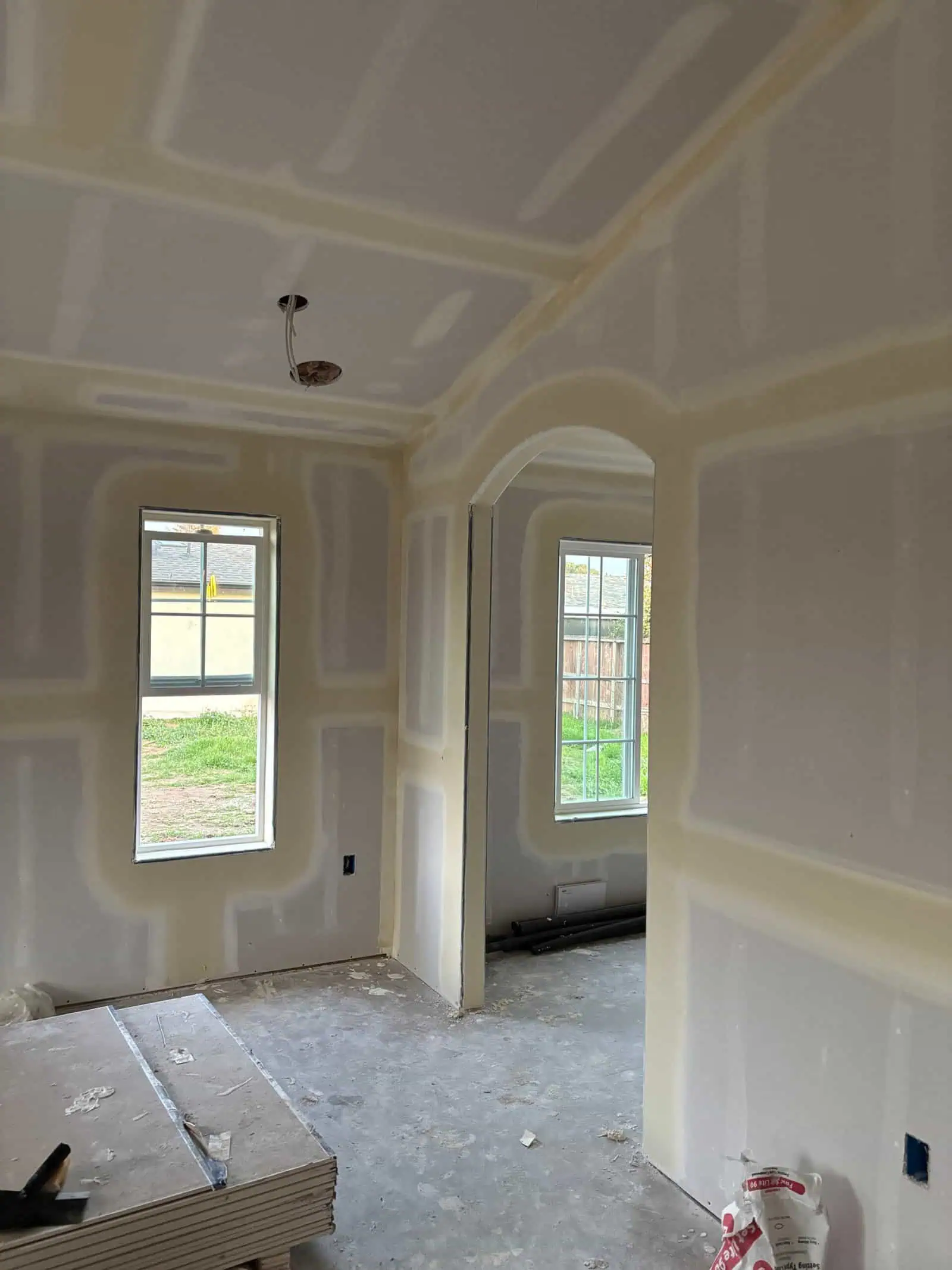 Newly Drywalled Room with Windows and Ceiling Details.