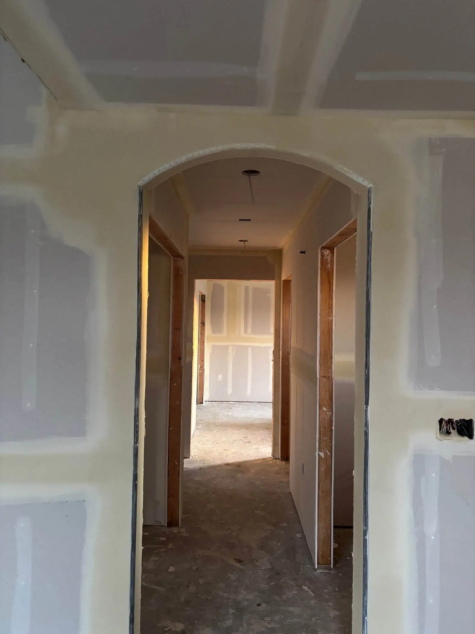 Interior drywall installation with archway in a residential home.