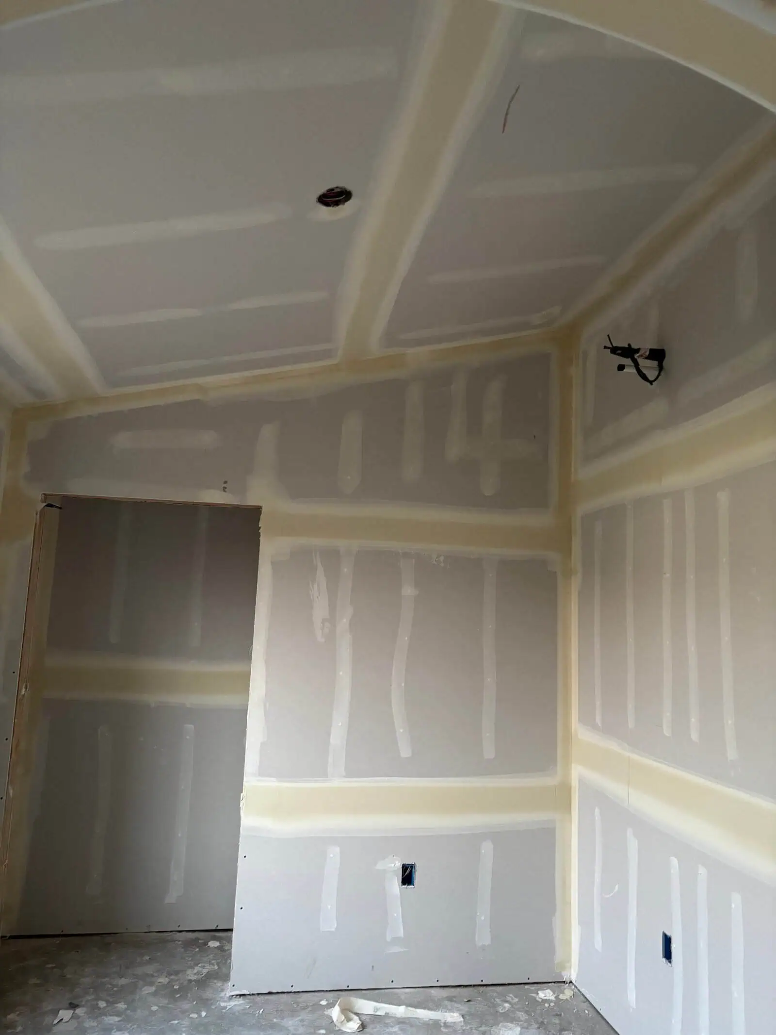 Newly installed drywall with joint tape and mud in a residential room.