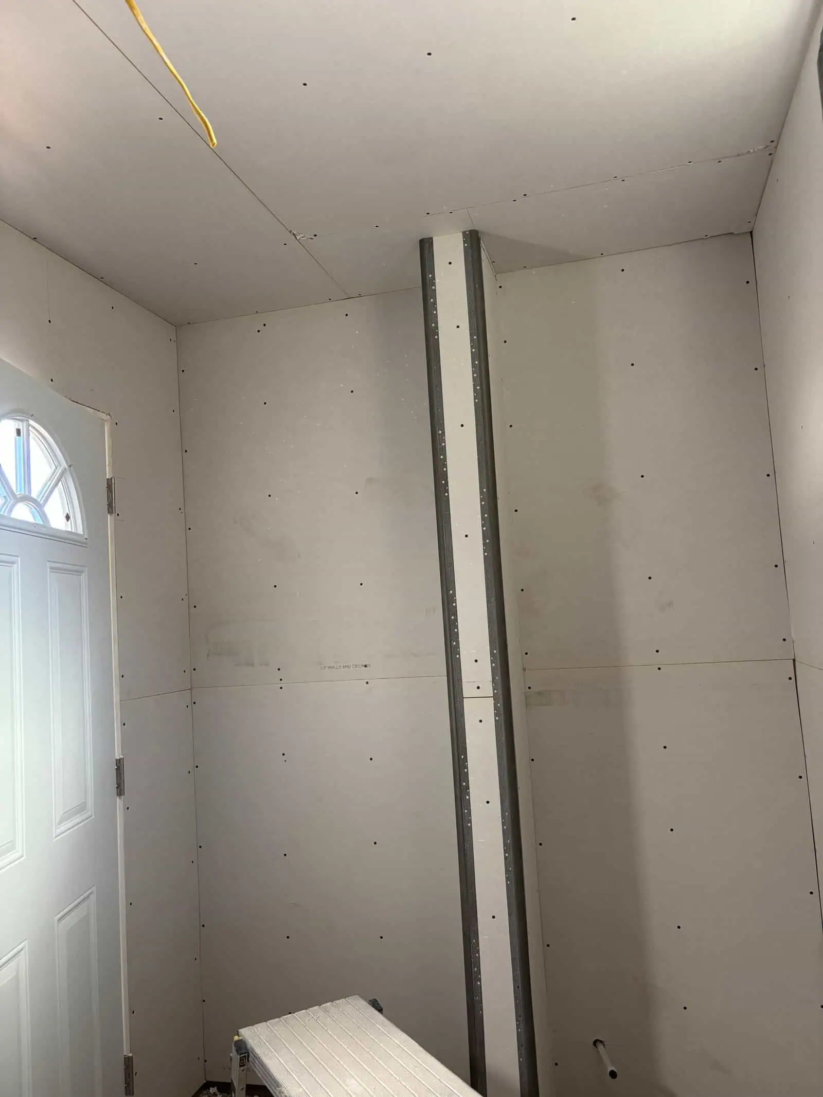 Interior drywall installation with metal studs in a residential space.
