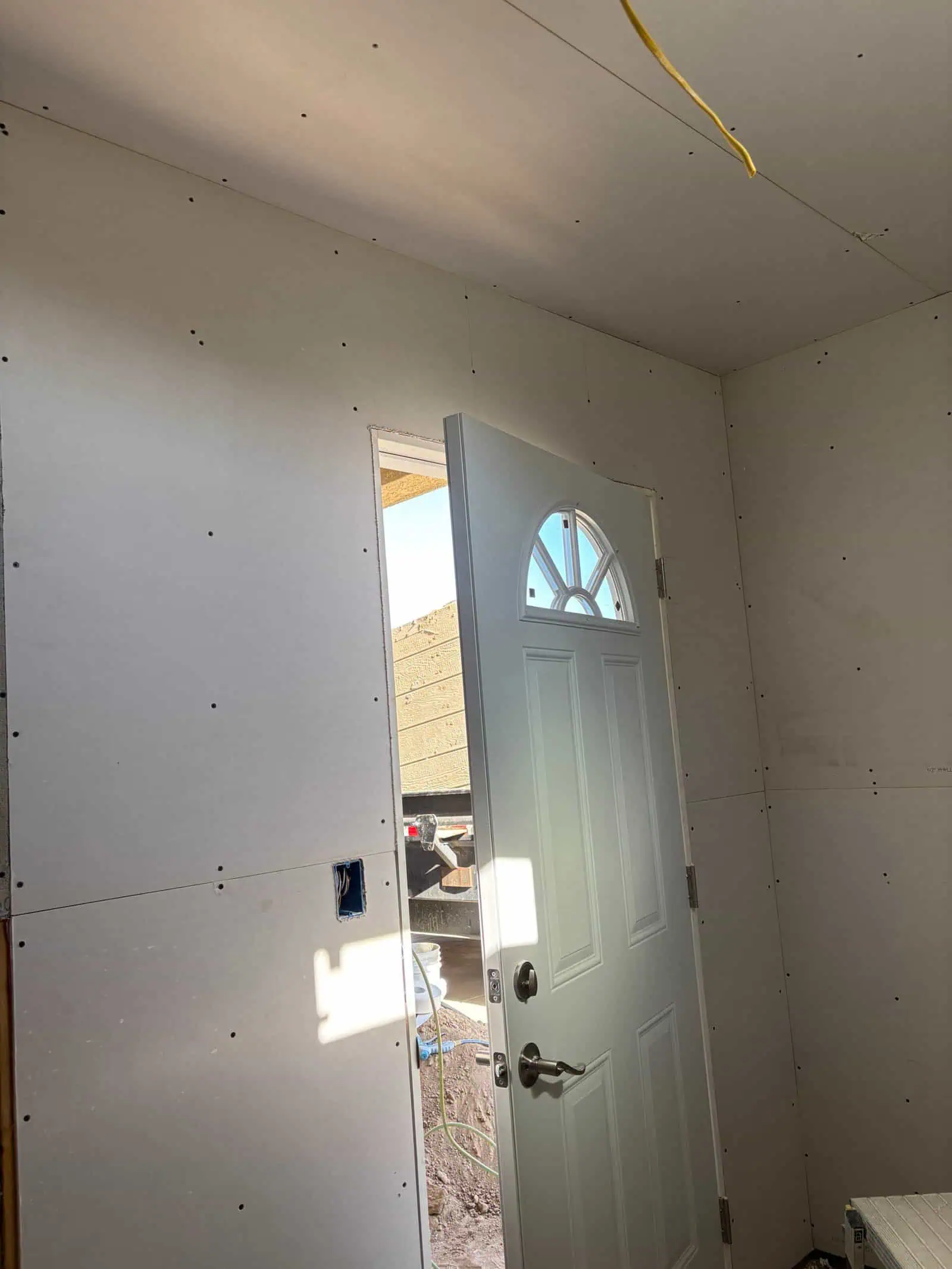 Interior drywall installation with door frame in progress at Priority Drywall.