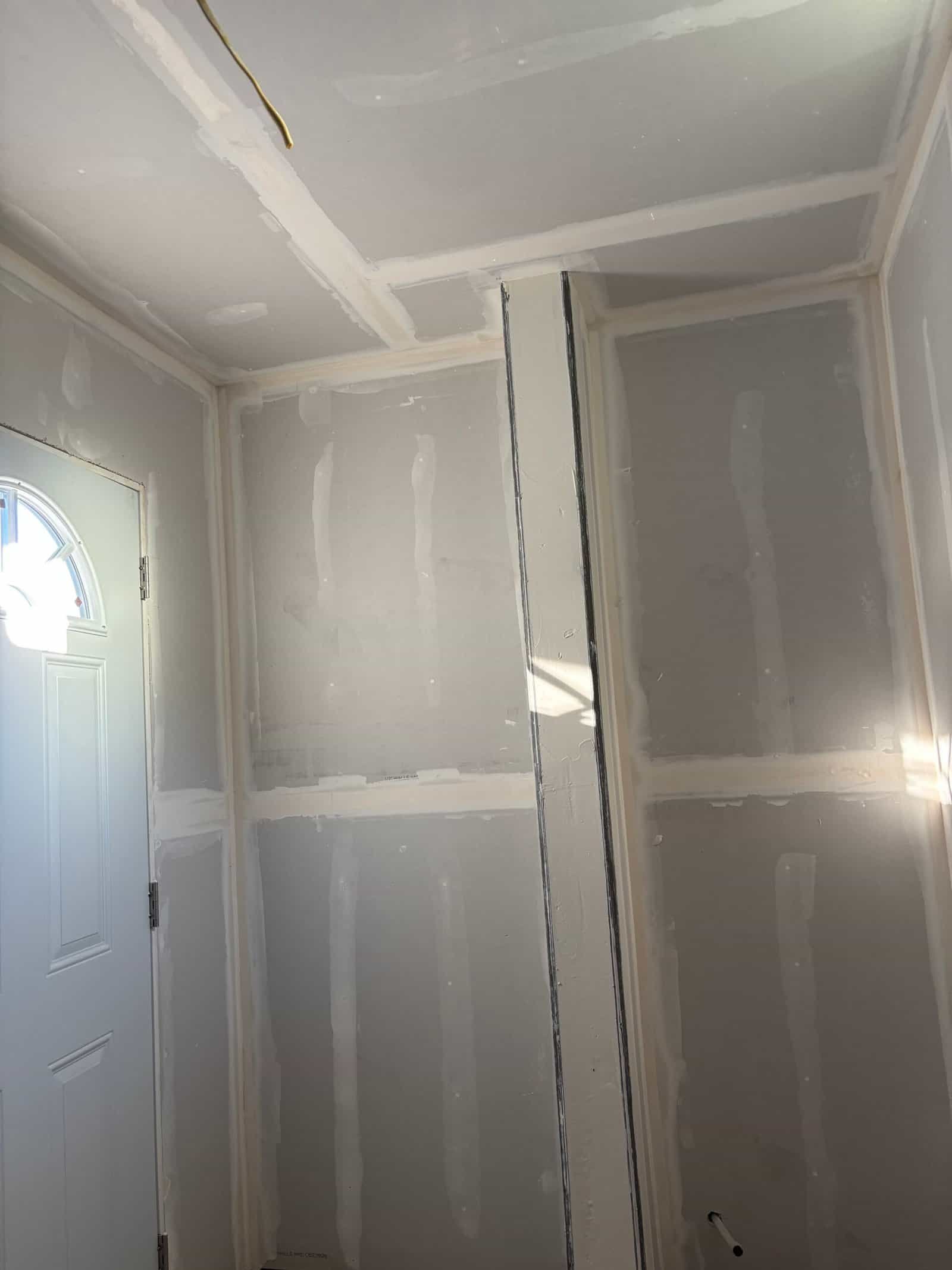 Interior drywall installation with unfinished walls and ceiling.