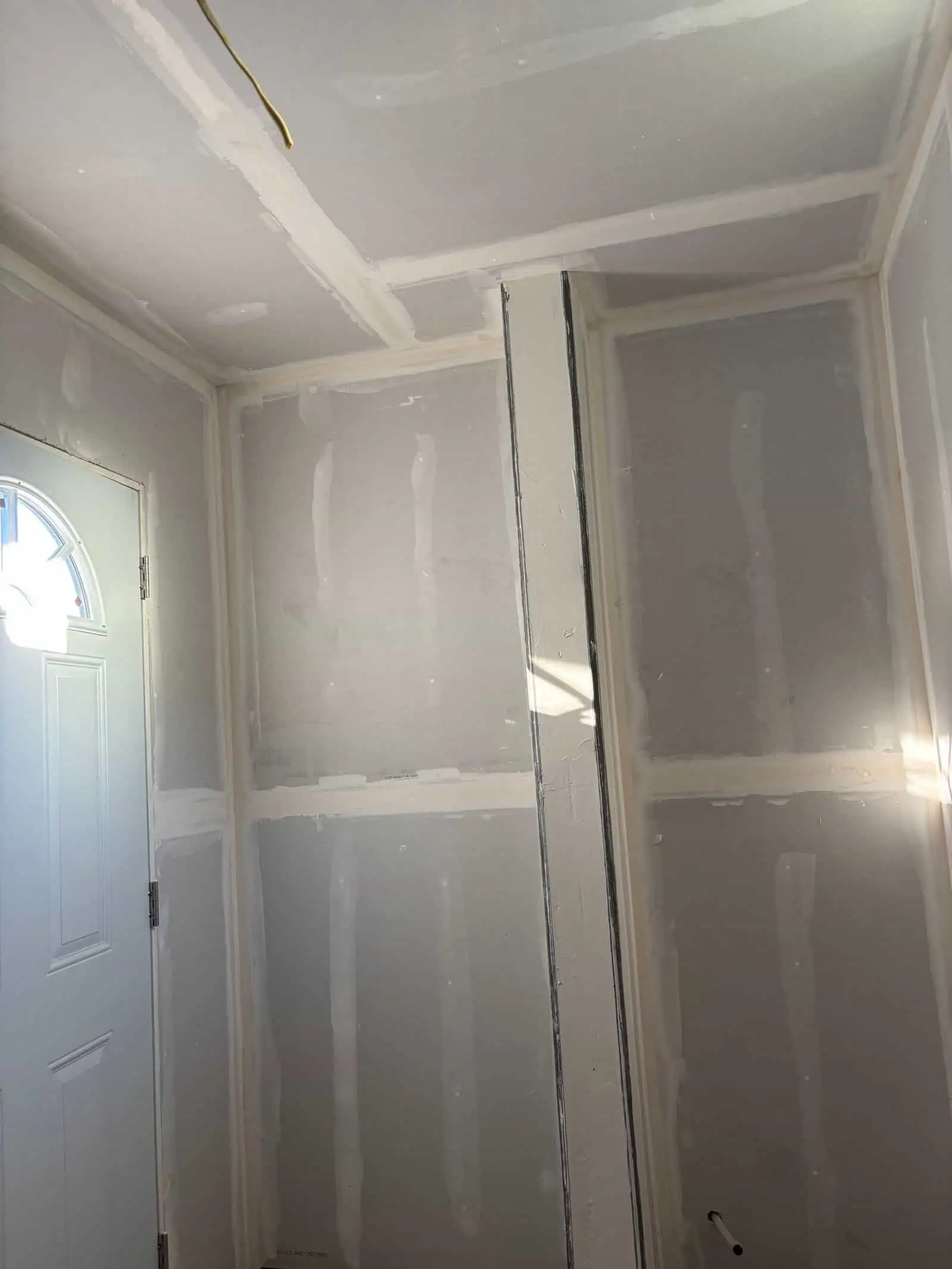 Interior drywall installation with unfinished walls and ceiling.
