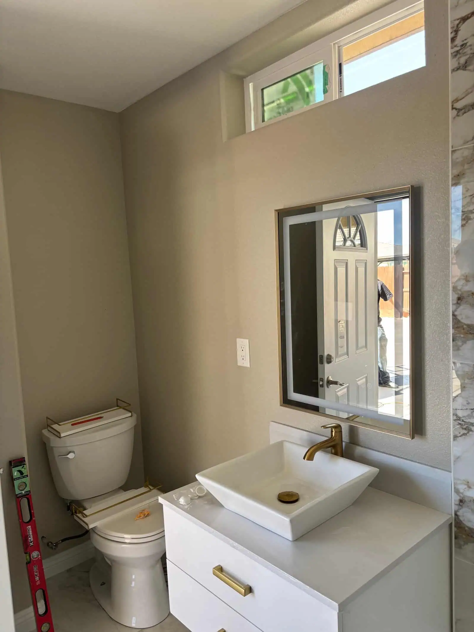 Contemporary bathroom with vanity, mirror, and toilet in new home.